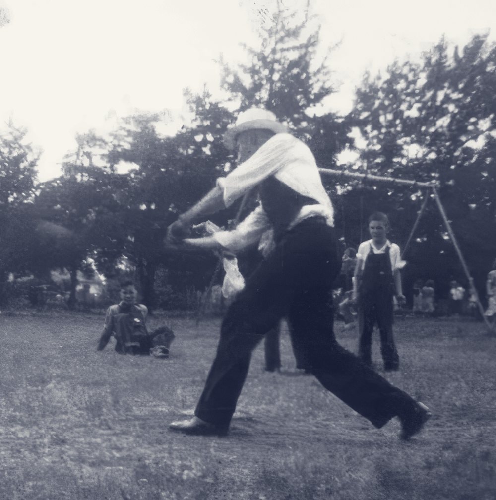 Father Emil Kapaun batting during a children's baseball game in Pilsen, Kansas